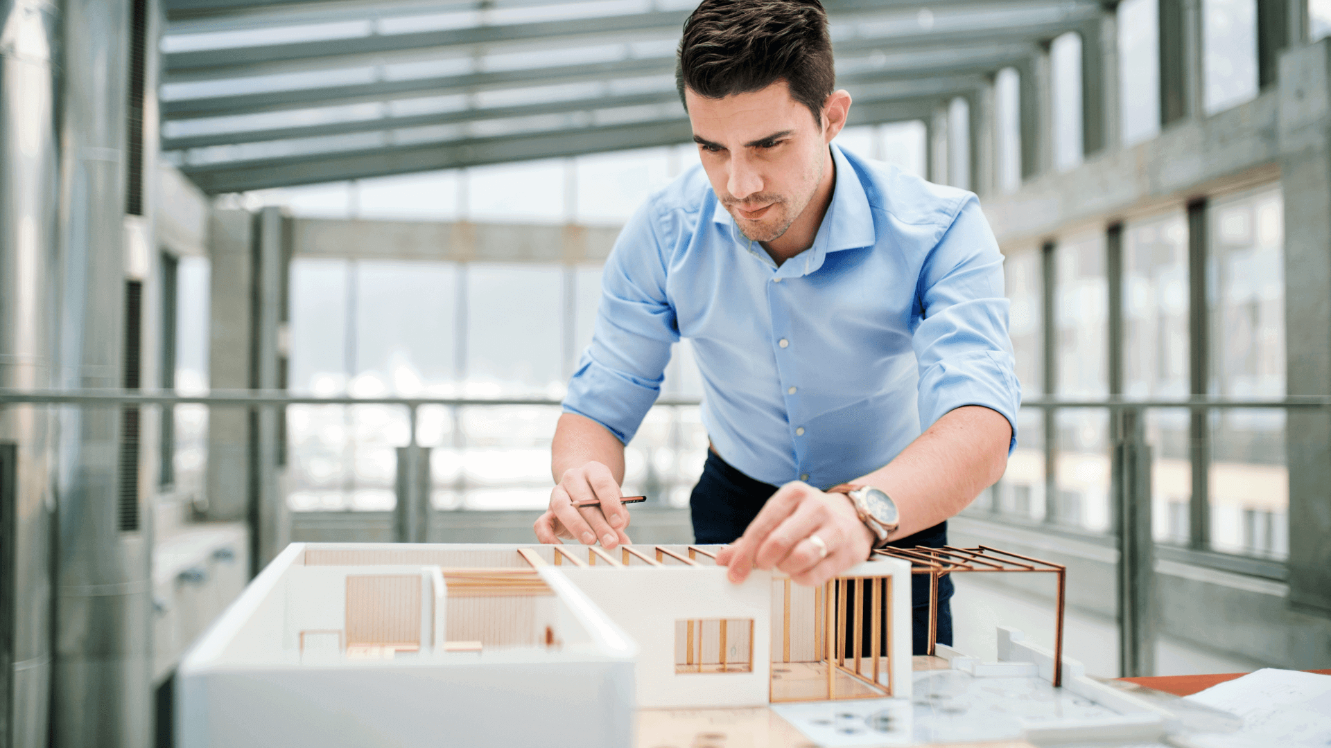 Architekt von Binder Bau arbeitet konzentriert an einem Architekturmodell – Symbol für präzise Planung und umfassende Baudienstleistungen.